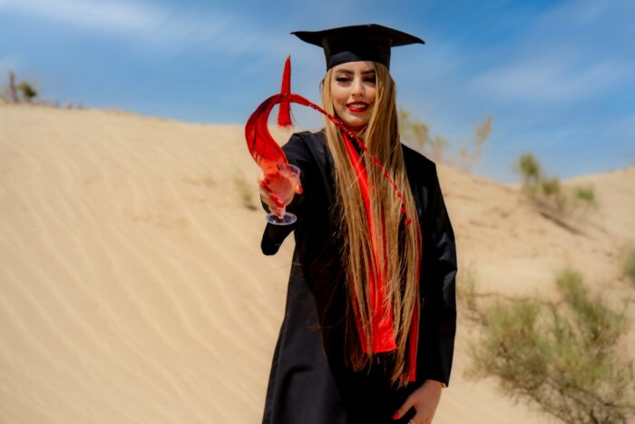 a woman in a graduation gown holding a red object