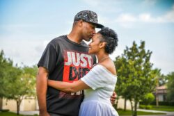 man in black crew neck t-shirt kissing woman in white dress